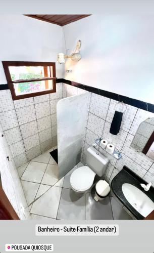 a bathroom with a white toilet and a sink at Hospedagem La Bilbaina in Porto Seguro