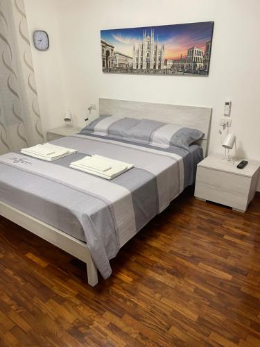 1 dormitorio con 1 cama grande y suelo de madera en Casa Iris, en Rozzano
