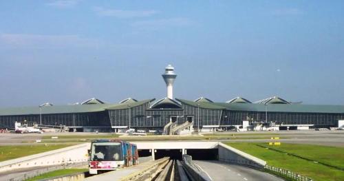 a bus driving down a road in front of an airport at Alanis Suite With Netflix @ KLIA Sepang in Sepang