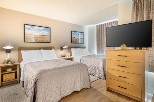 a hotel room with two beds and a flat screen tv at InTown Suites Extended Stay Marietta GA - Town Center in Kennesaw