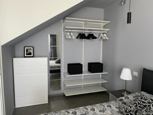 a bedroom with a bed and a white book shelf at Polinesia 5 in Lido delle Nazioni