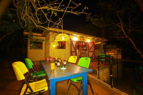 a table and chairs on a patio at night at Zion Country in Manchioneal
