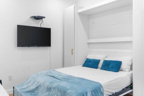 a bedroom with a bed with blue pillows and a flat screen tv at 316 Footloose #1 in Hollywood