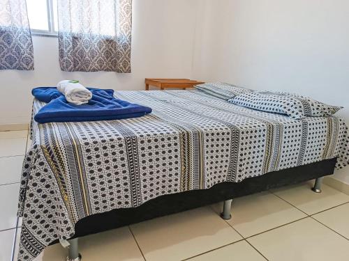 a bed with a blanket on top of it at Pousada BR101 in Angra dos Reis