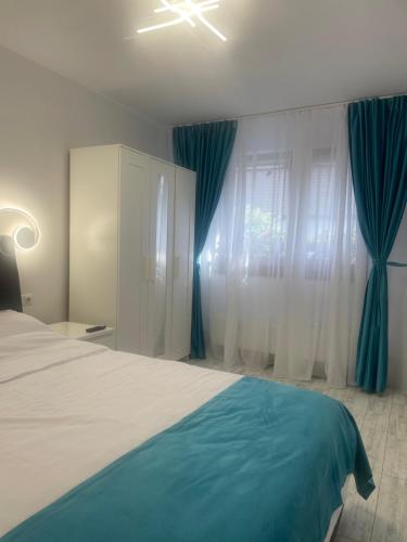een slaapkamer met een groot bed en blauwe gordijnen bij Casa Anita in Sighişoara