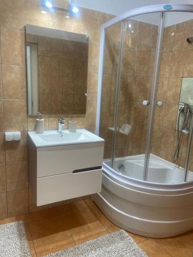 een badkamer met een douche, een wastafel en een bad bij Casa Anita in Sighişoara