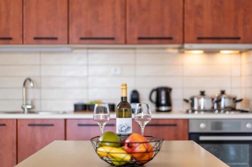 a kitchen with two wine glasses and a bowl of fruit at K&D Central Suite in Sitia