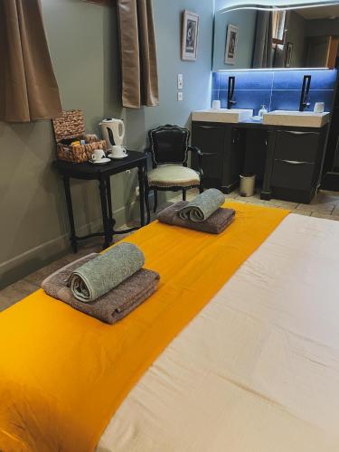 a room with a bed with two towels on it at Au bout du pré in Pézenas