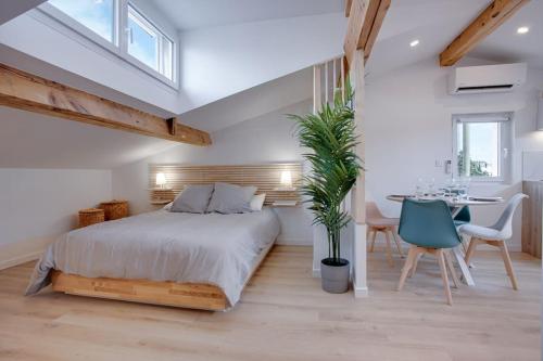 um quarto com uma cama, uma mesa e cadeiras em Le Saint-éxupery em Toulouse