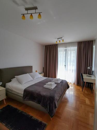 a bedroom with a large bed and a desk at Apartments Radovic in Podgorica
