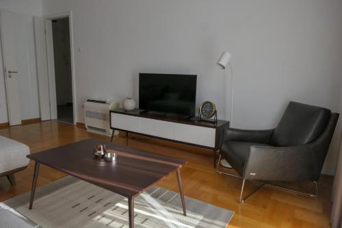 a living room with a television and a table and chairs at Apartments Radovic in Podgorica