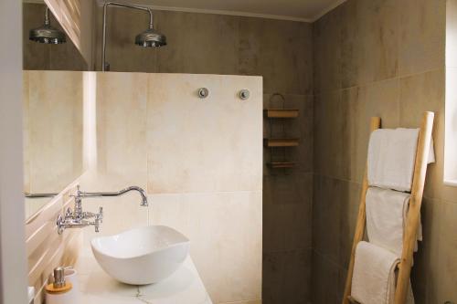 een badkamer met een witte wastafel en een douche bij Akropolis Village Complex of Luxury Residence in Karpathos