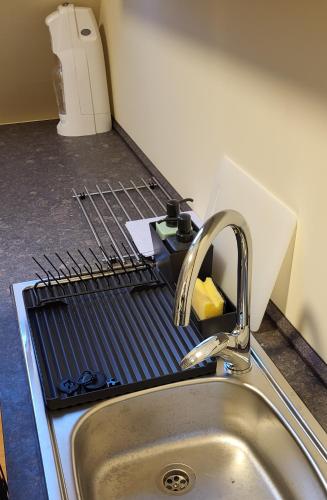 a kitchen sink with a drying rack next to it at Apartmán Husovka Bruntál - pokoj POLLY in Bruntál