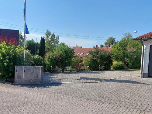 a brick parking lot with a flag and a building at Pension am Kirchberg in Wehringen