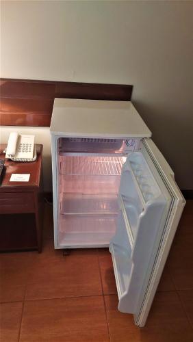 an empty refrigerator with its door open next to a desk at Lima Wasi Hotel Miraflores in Lima