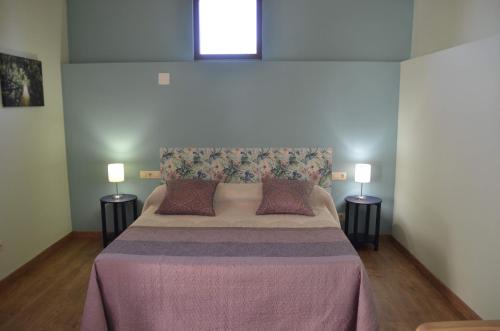 a bedroom with a large bed with two lamps at Casa Atenea in Zamora