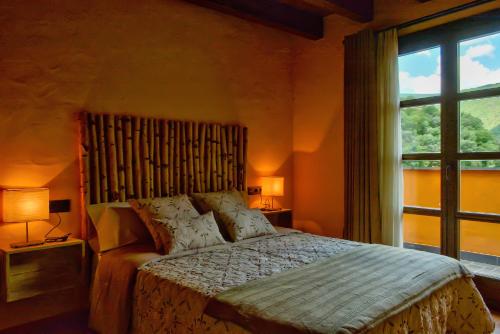 a bedroom with a bed and a large window at La Rectoria in Vall de Castellbò