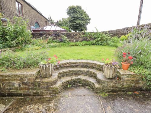 a stone stairway in a garden with flowers and plants at Ash Tree Barn in Clayton