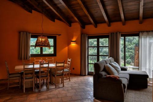 a living room with a couch and a table and chairs at La Rectoria in Vall de Castellbò