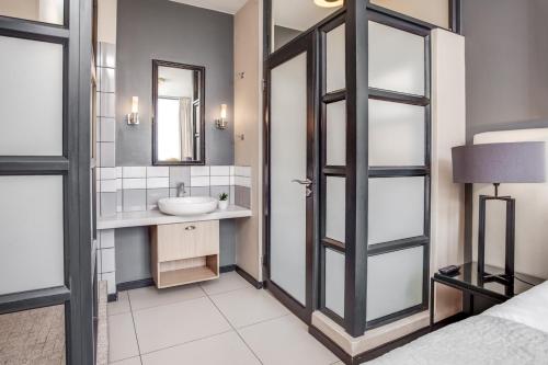 a bathroom with a sink and a mirror at Urban Oasis Apartments at The Vantage in Johannesburg