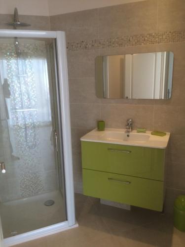 La salle de bains est pourvue d'un lavabo vert et d'une douche. dans l'établissement Les Jasmins, à Sainte-Maxime