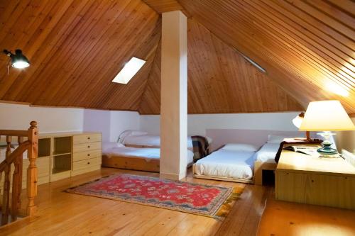 a attic room with two beds and a desk at Balaitus ❆ Atico de 120m2 con garaje ✿❀✿ in Sallent de Gállego