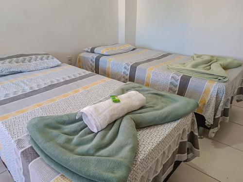 three beds with blankets on them in a room at Pousada BR101 in Angra dos Reis