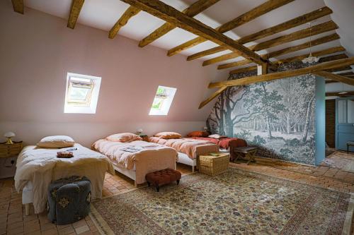 ein Schlafzimmer mit 2 Betten und einem Wandgemälde in der Unterkunft Maison d'hôtes et gîte en Sarthe in Saint-Christophe-en-Champagne