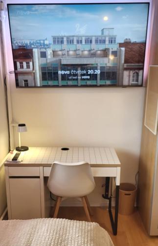 a desk with a white chair in front of a window at Apartmán Husovka Bruntál - pokoj POLLY in Bruntál