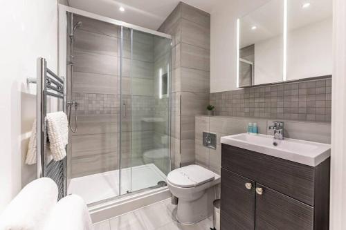 a bathroom with a shower and a toilet and a sink at Modern Buckingham Palace Apartment in London