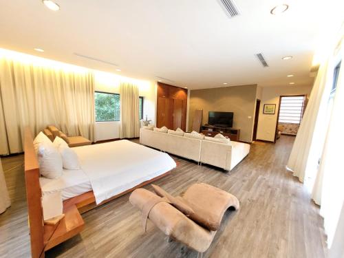 a large bedroom with a large bed and a couch at Bạch Yến T111-Happy Villa Đại Lải Resort in Vĩnh Phúc