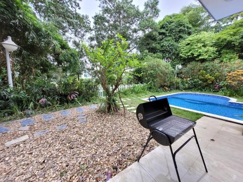 a black grill sitting next to a swimming pool at Bạch Yến T111-Happy Villa Đại Lải Resort in Vĩnh Phúc
