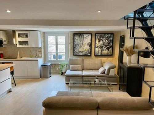 a living room with a couch and a kitchen at Superbe duplex, Centre historique, 5 personnes in Bellême