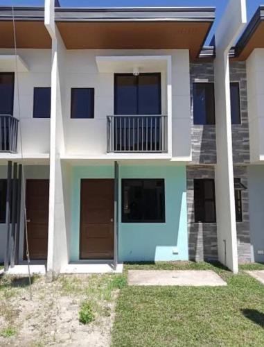 a house with a blue door and a balcony at Casa Mira Coast Apartment with Motorbike in Dumaguete