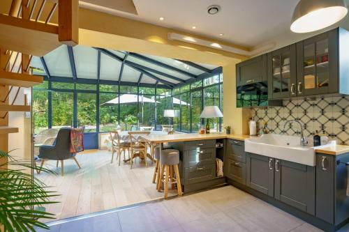 une cuisine avec des armoires vertes et une salle à manger avec une table dans l'établissement Le Gîte de l'Ormoy, à Saint-Laurent