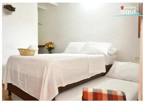 a bedroom with a white bed and a couch at Quedate Aqui Barichara - El Original in Barichara