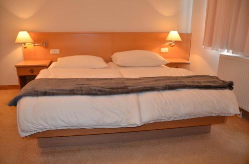 a bedroom with a large bed with two pillows at Die Pension Galle in Arnoldstein