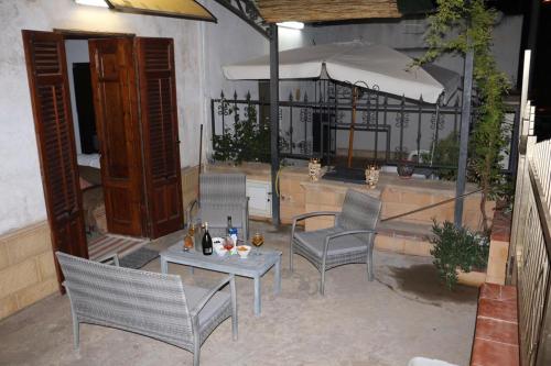 a patio with chairs and a table and an umbrella at Mare Nostrum TF in Tre Fontane