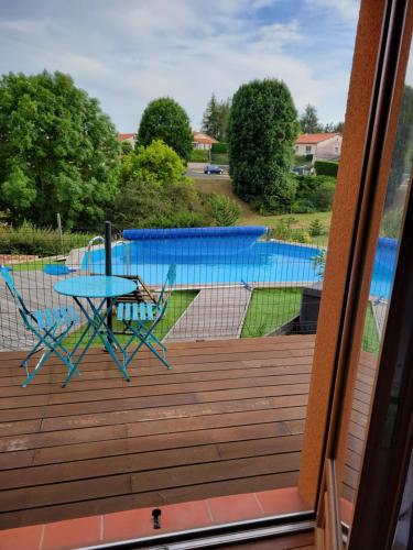 a deck with a table and chairs and a pool at Damarie in Craponne-sur-Arzon