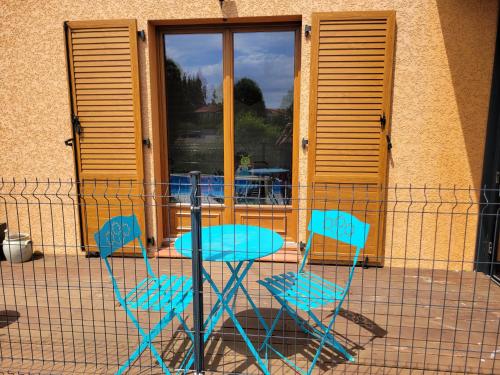 two blue chairs and a table in front of a building at Damarie in Craponne-sur-Arzon