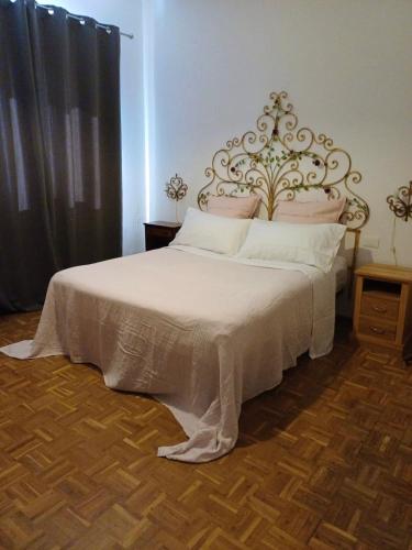 a bedroom with a large white bed with a metal headboard at Villamonestevole501 in Umbertide