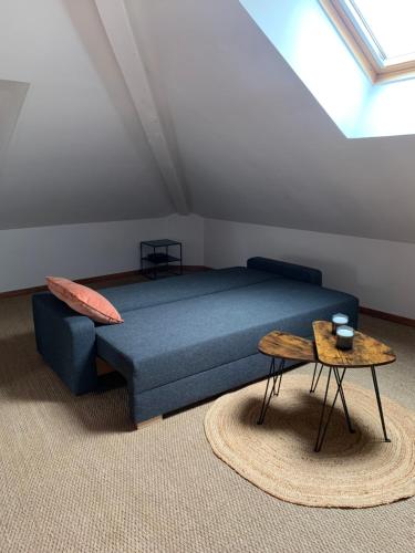 Un dormitorio con una cama azul y una mesa en La Bohè’m night, en Villeneuve-la-Guyard