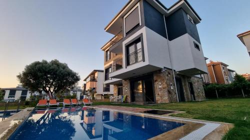 a house with a swimming pool in front of a house at Villa Begonvil in Kusadası