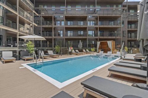 an outdoor swimming pool with chairs and a building at Skyline View, Pool, Gym, Balcony's, Walk to BWay! in Nashville