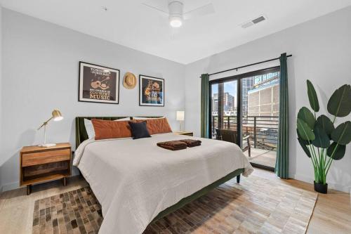 Un dormitorio blanco con una cama grande y una ventana en Skyline View, Pool, Gym, Balcony's, Walk to BWay! en Nashville