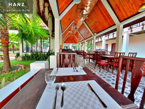 una sala da pranzo con tavoli e sedie in un ristorante di Sunrise Hotel Luang Prabang MekongRiver a Luang Prabang