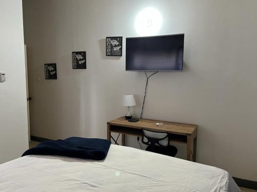 a bedroom with a bed and a desk with a television at Splendid Inn in Florence Hall