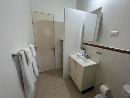 a white bathroom with a sink and a mirror at Splendid Inn in Florence Hall