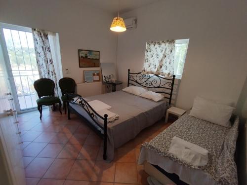 a bedroom with a bed and two chairs and a window at CostasFarmhouse, Pallini, Near Athens Airport in Pévka
