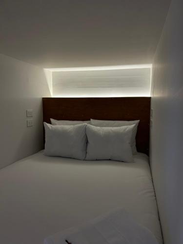a bed with white pillows in a white room at Casa Tunki in Cusco